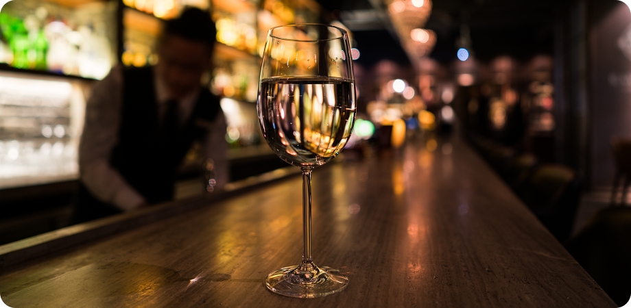Glass of liquor on bar counter illustrating liquor license application process.