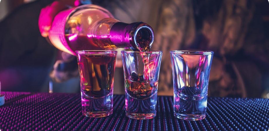 Shots being poured on a lit bar for buying a liquor license in Delray Beach